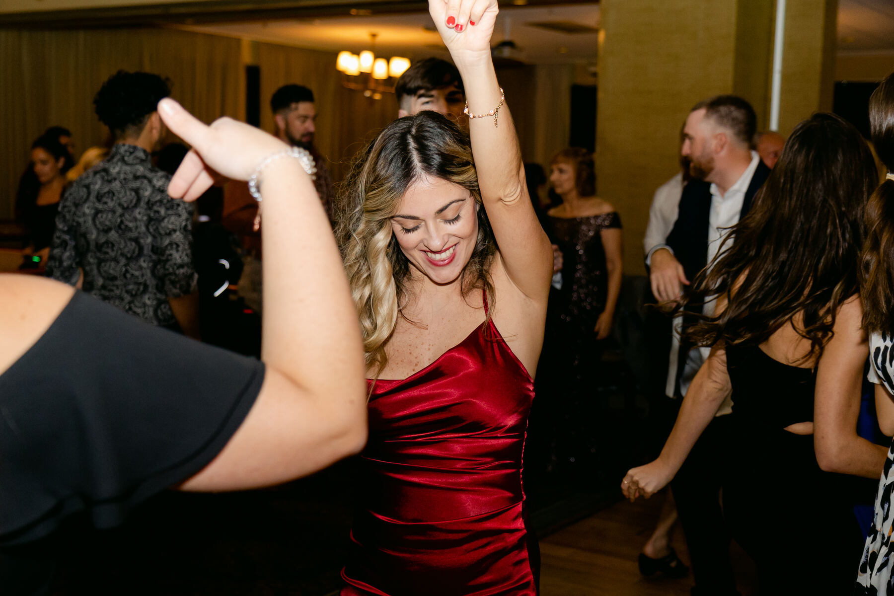 A guest in a red dress dancing under the lights